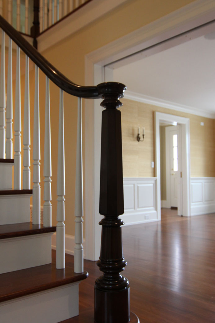 a classically inspired custom newel post and balusters provide a timeless element to this country home, all designed in collaboration with our client
